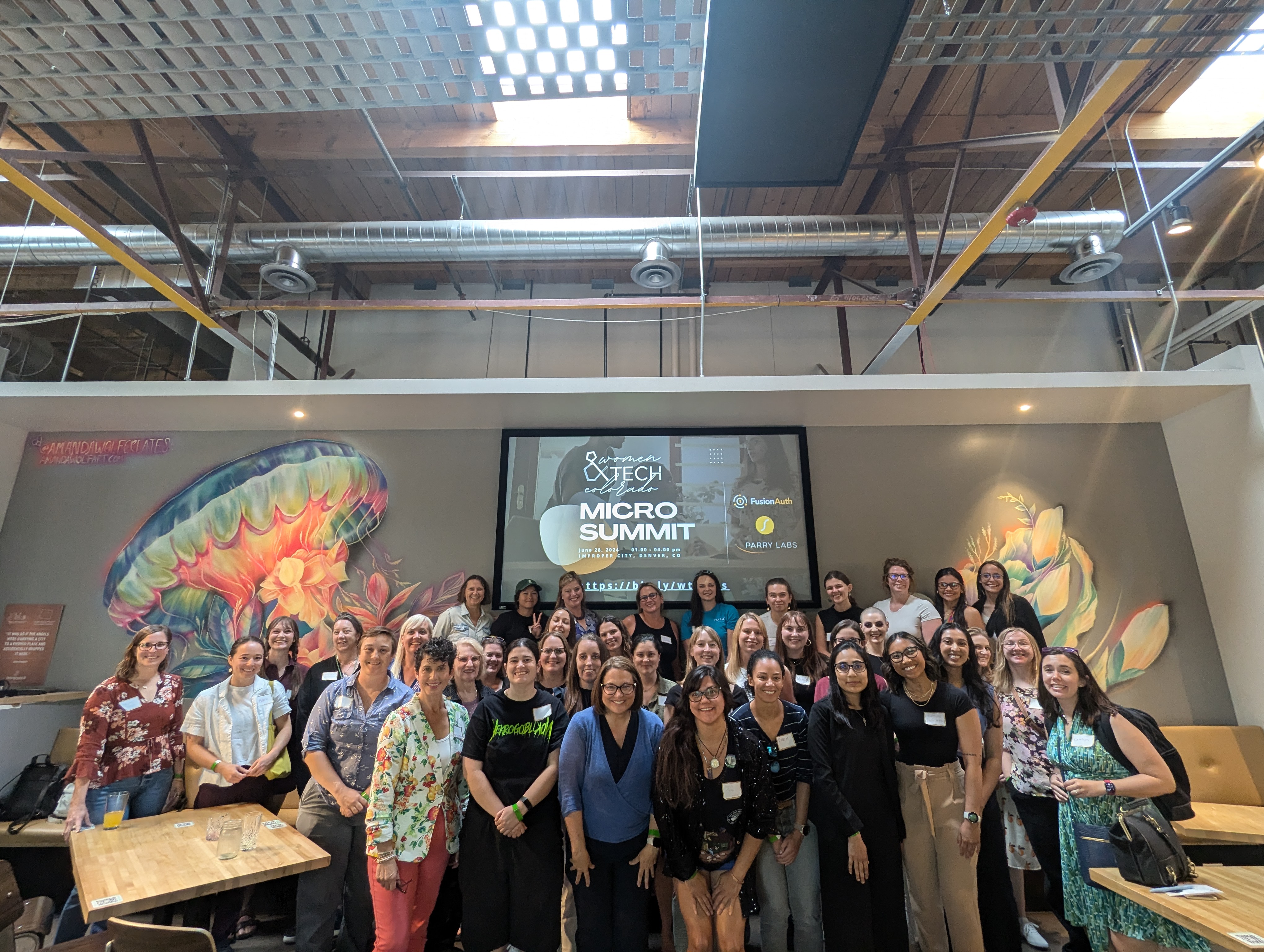 Women&TECH Micro Summit group photo with presentation screen